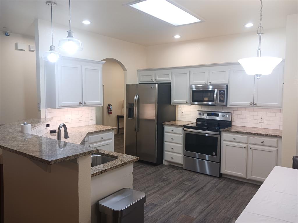 a kitchen with kitchen island a sink stainless steel appliances and cabinets