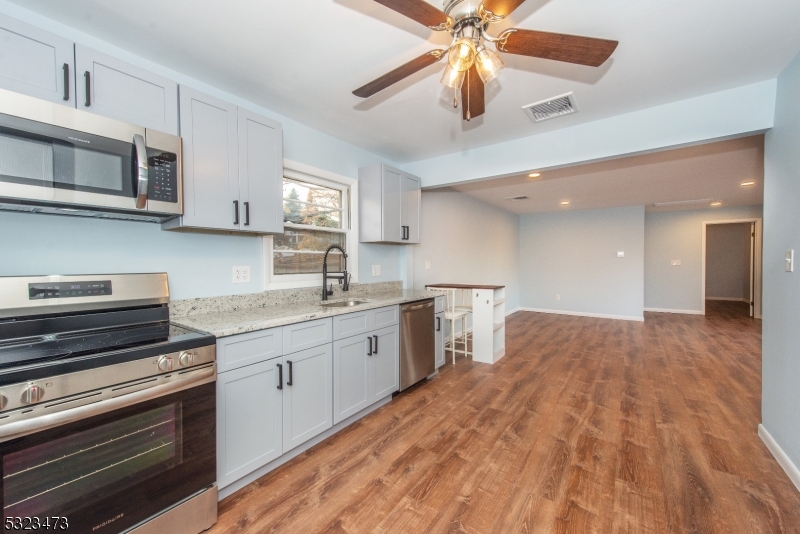 a kitchen with stainless steel appliances granite countertop a sink and cabinets