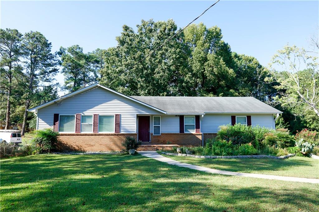 a front view of a house with a yard and trees