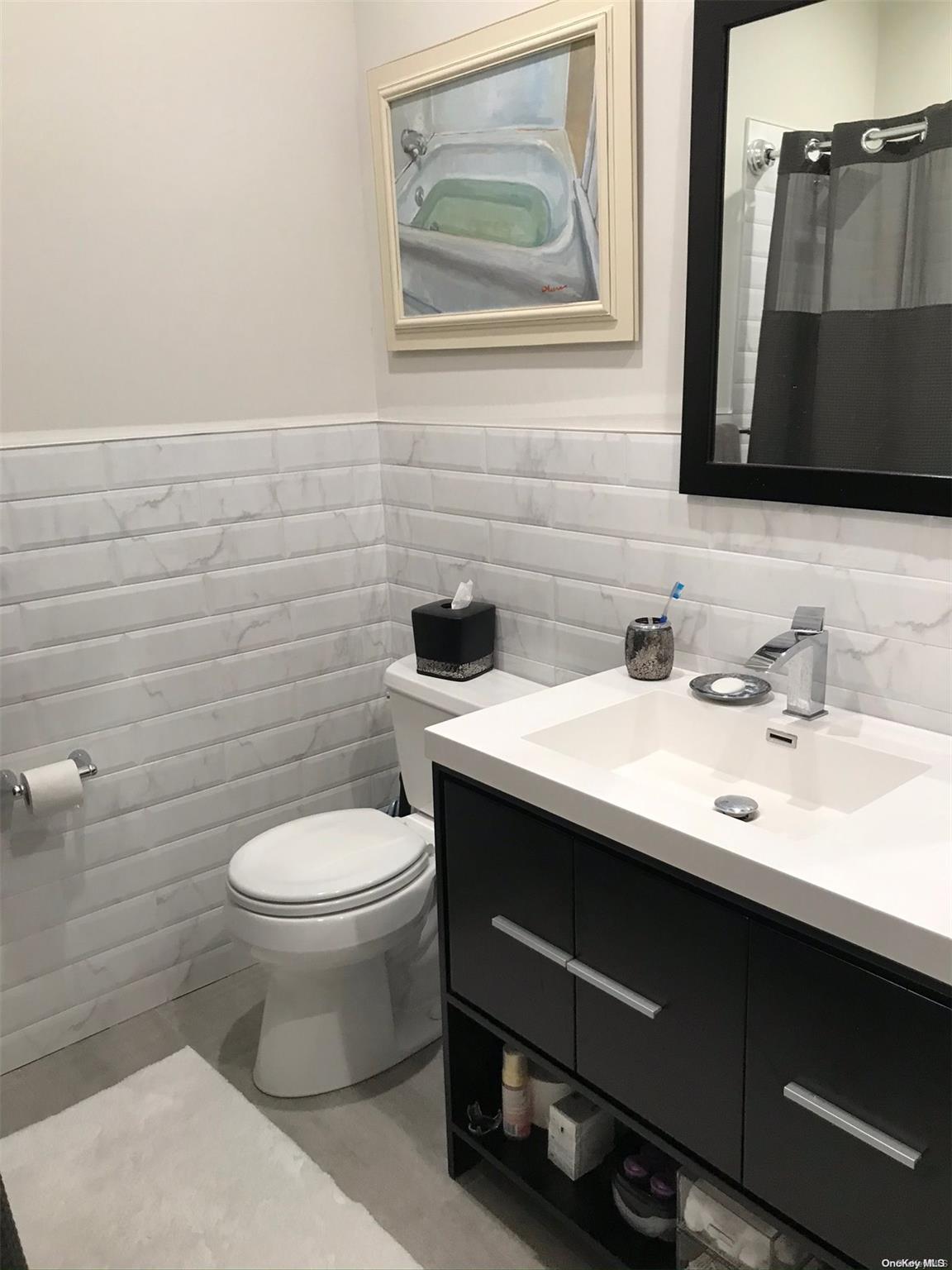 a bathroom with a sink mirror and toilet