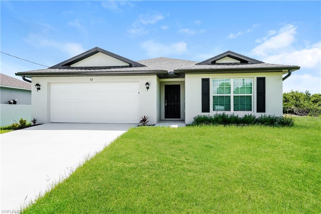 Single story home with a garage and a front lawn