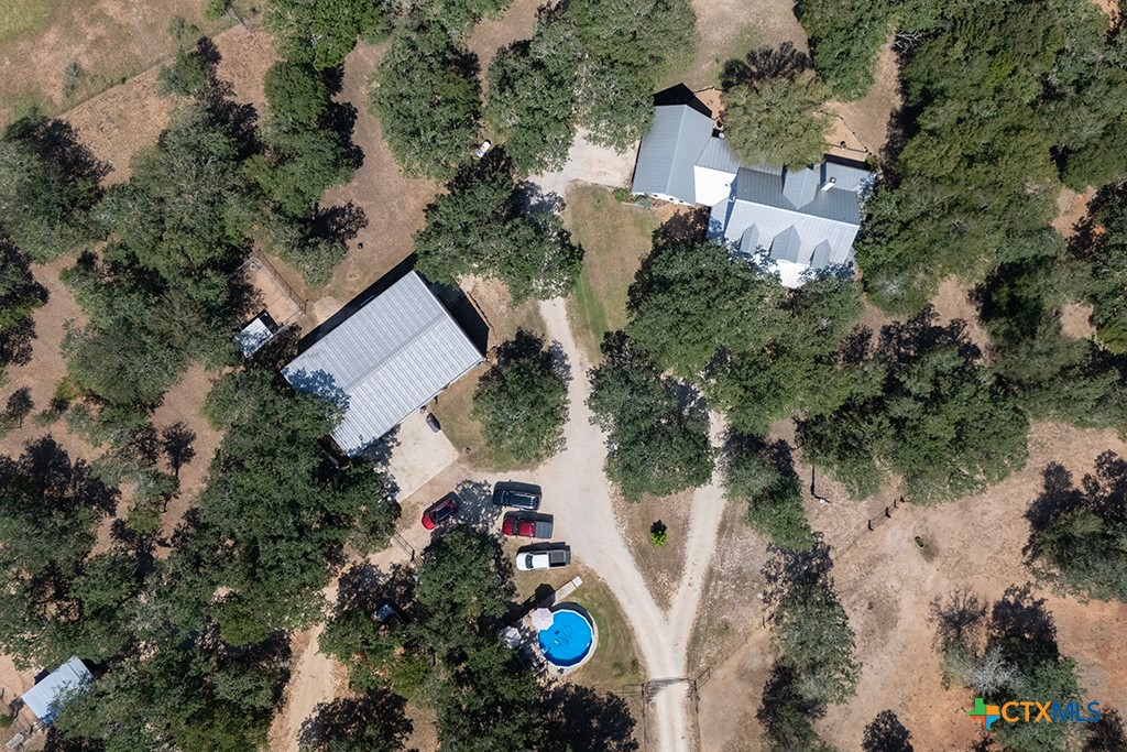 an aerial view of a house with a yard and greenery