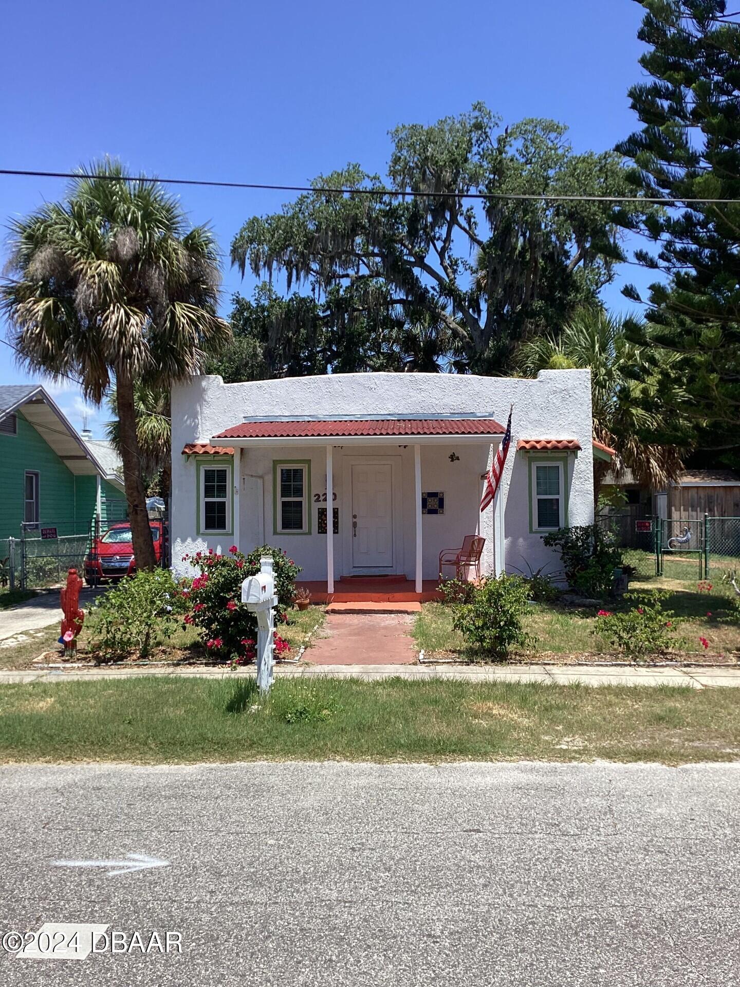 a front view of a house with a yard and outdoor seating