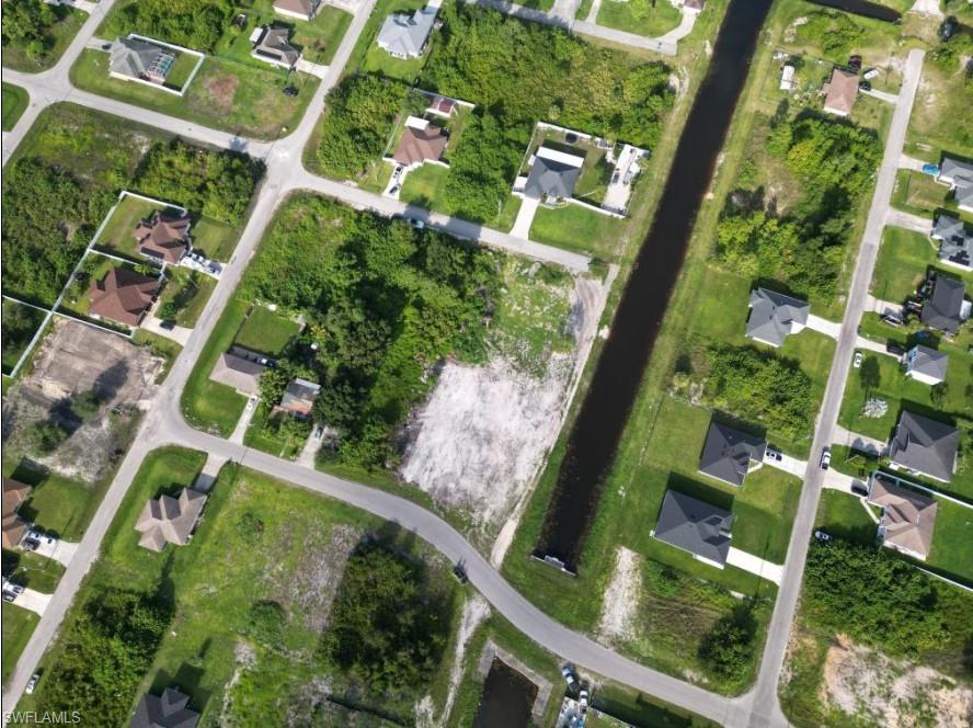 an aerial view of a residential houses with yard