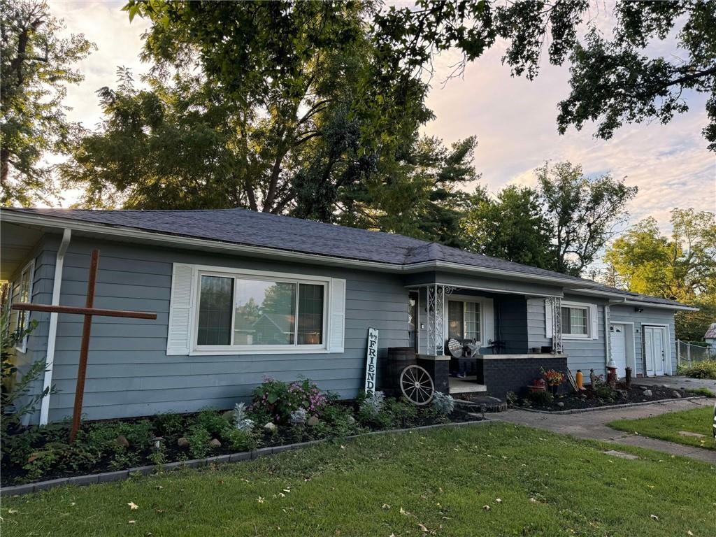 a front view of a house with a garden and trees