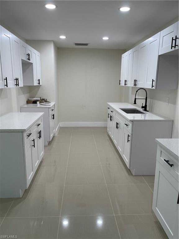 a large kitchen with stainless steel appliances a sink a stove and cabinets