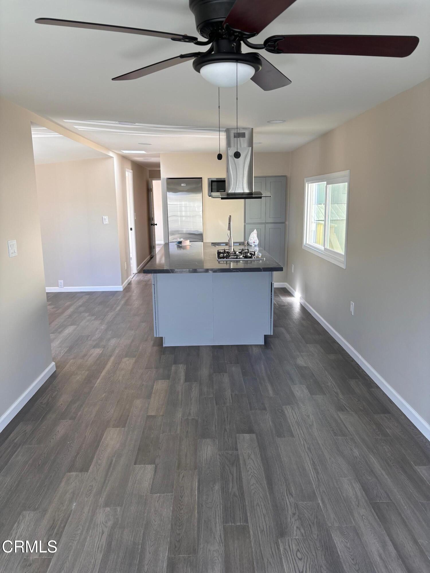 a large kitchen with cabinets wooden floor and stainless steel appliances