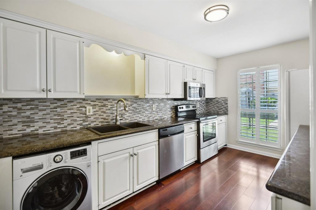 a kitchen with granite countertop a sink a stove and cabinets