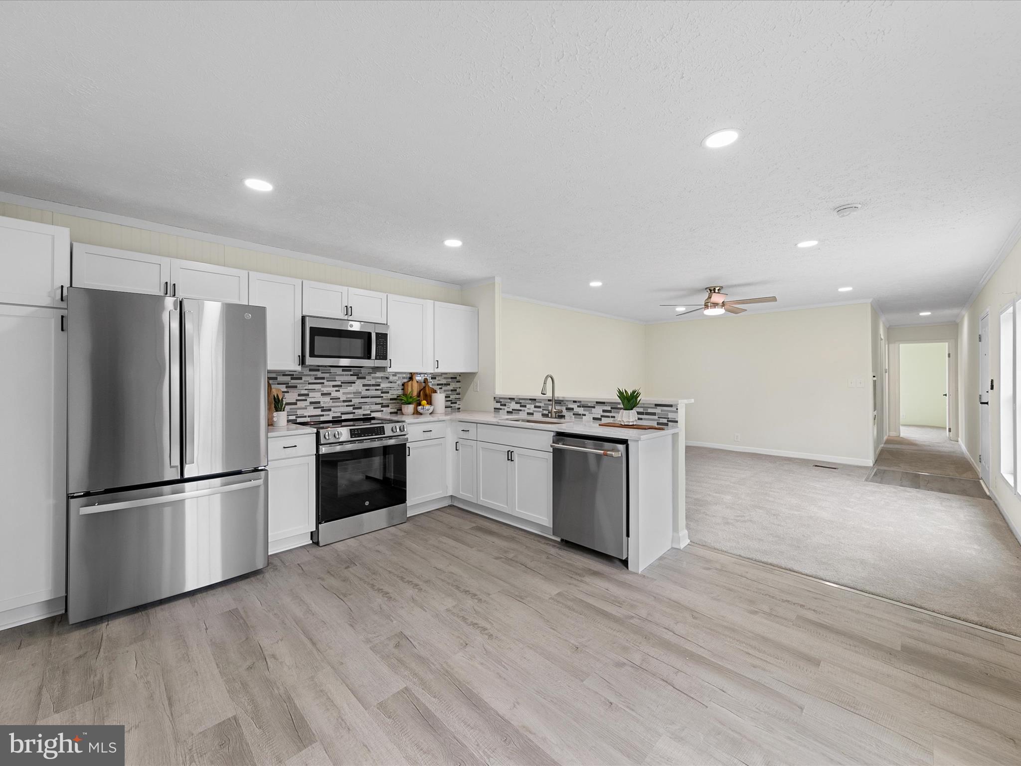 a kitchen with granite countertop a refrigerator and a stove top oven