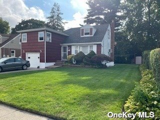 a front view of a house with a garden and plants