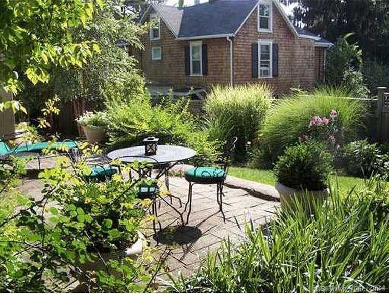 a view of a chairs and table in a backyard of a house