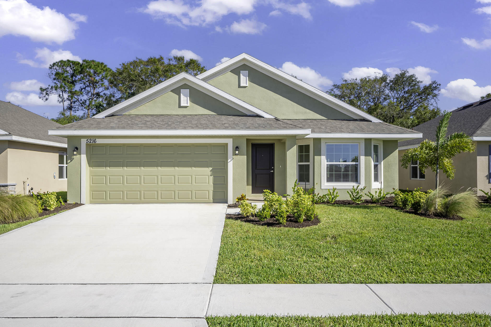 a front view of a house with a yard and garage