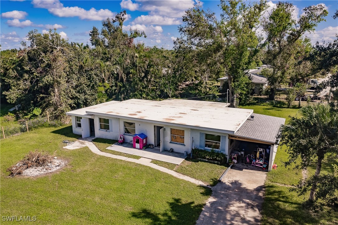 an aerial view of a house with swimming pool and large trees