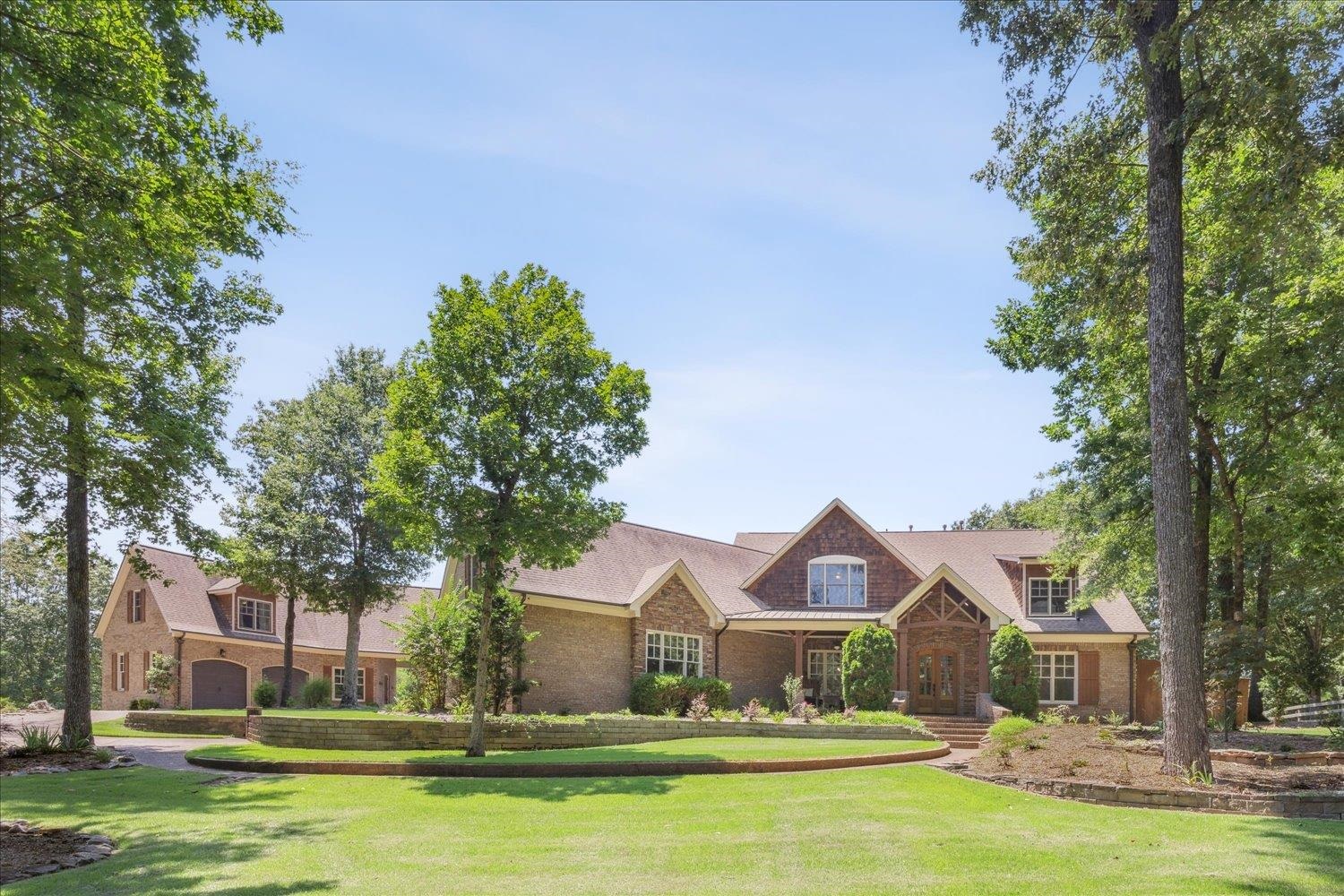 a front view of a house with garden and trees