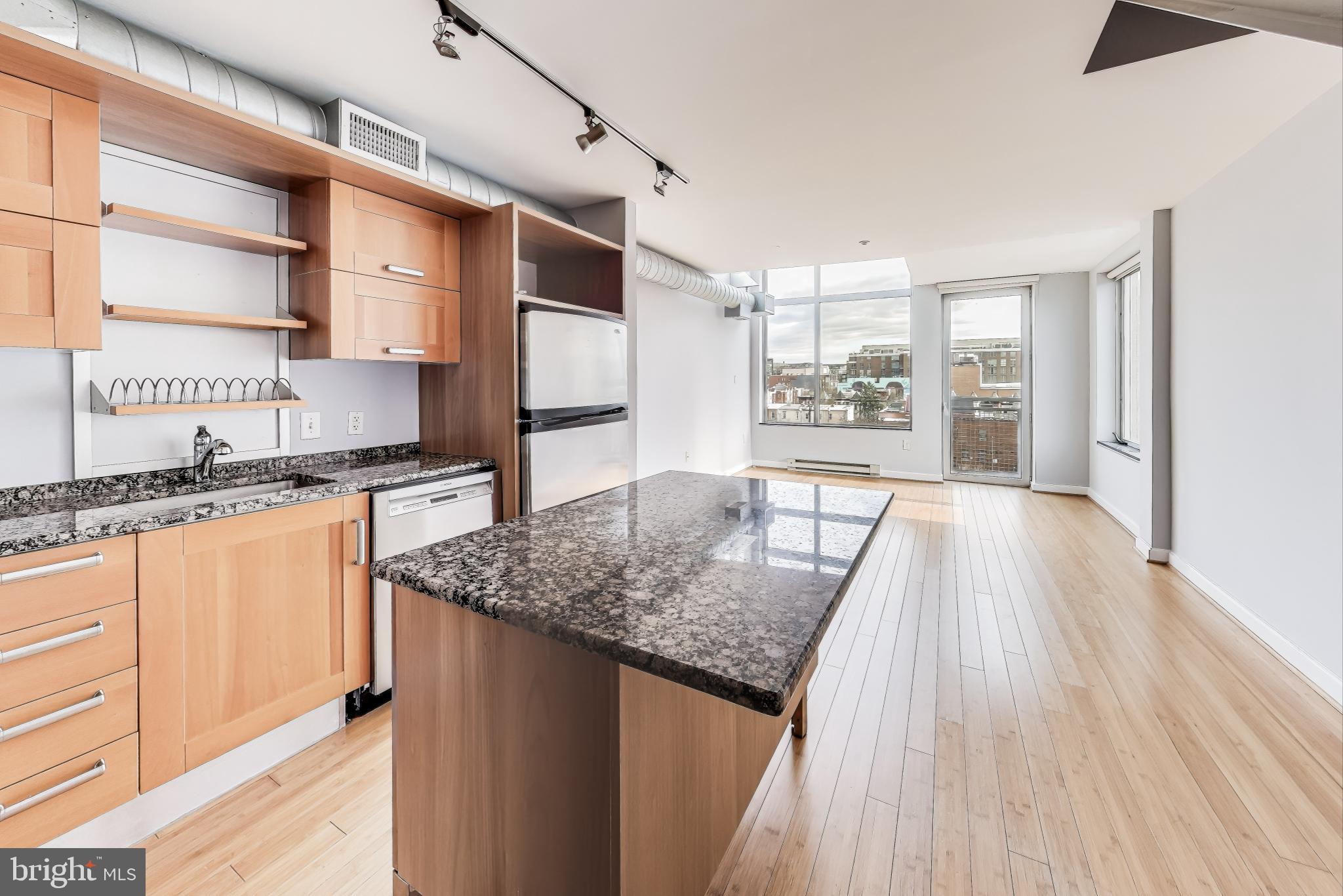 a kitchen with stainless steel appliances granite countertop a sink window and cabinets