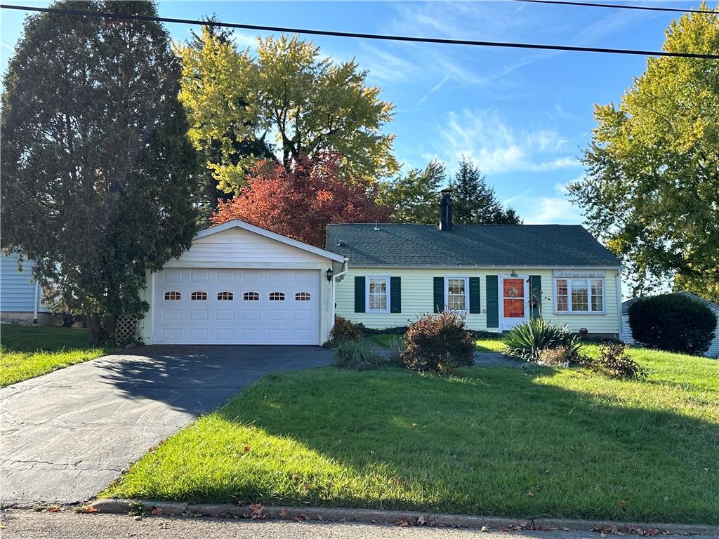 a view of a yard in front of a house with large windows