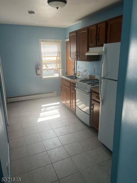 a kitchen with granite countertop a refrigerator and a stove top oven