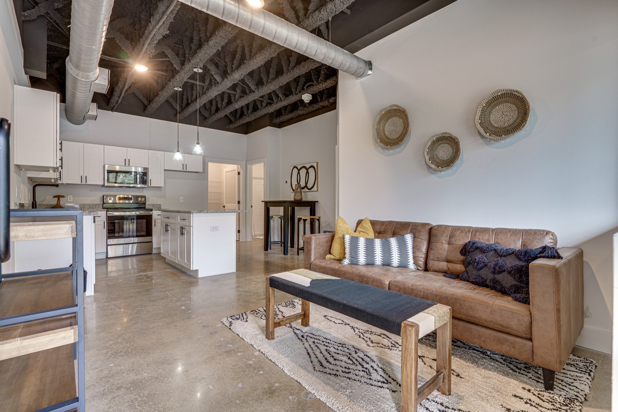 a living room with lots of furniture and kitchen view