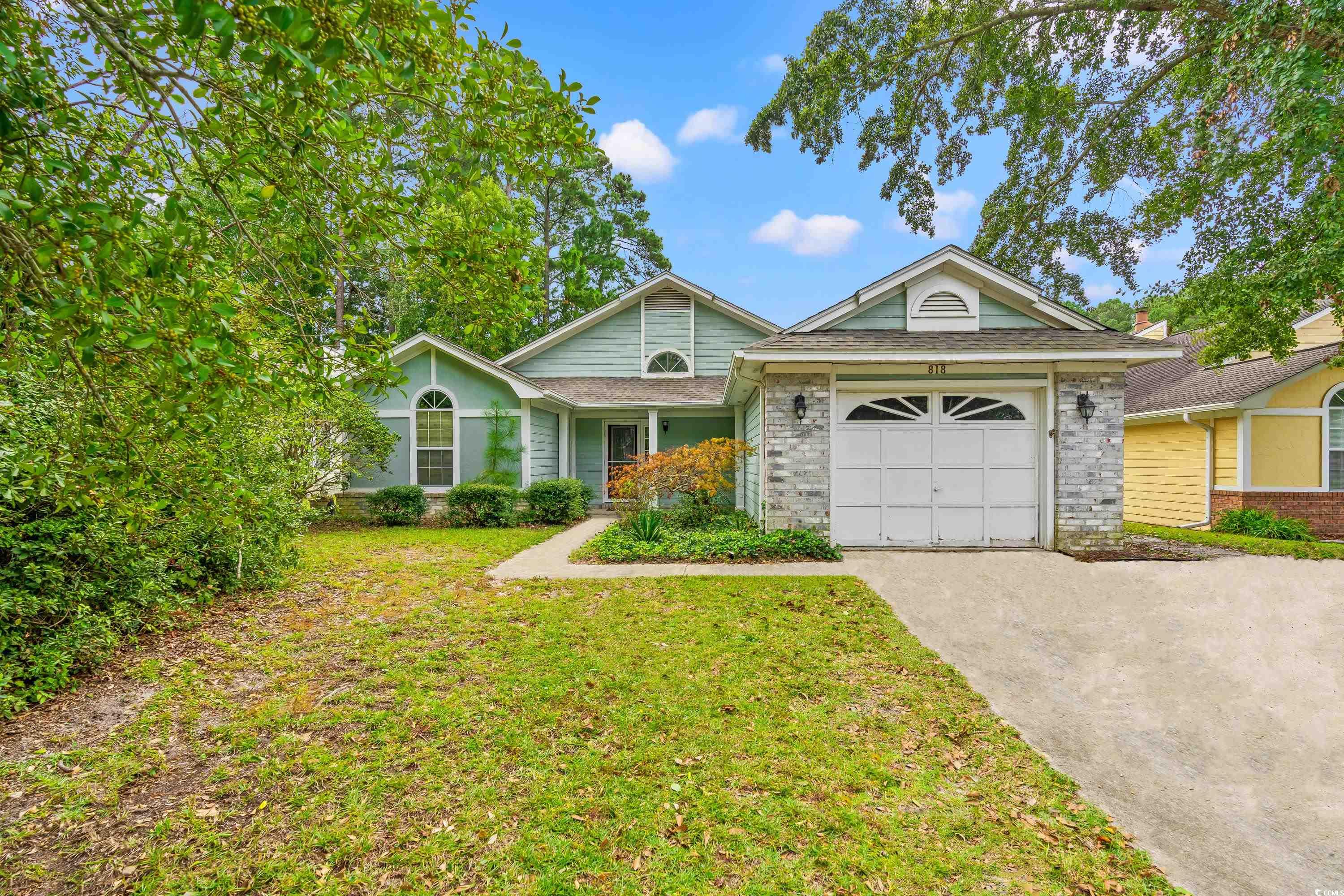 View of front of home with a front lawn and a gara