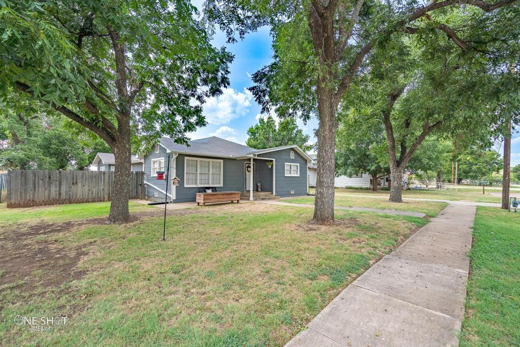 a view of a house with backyard and a tree