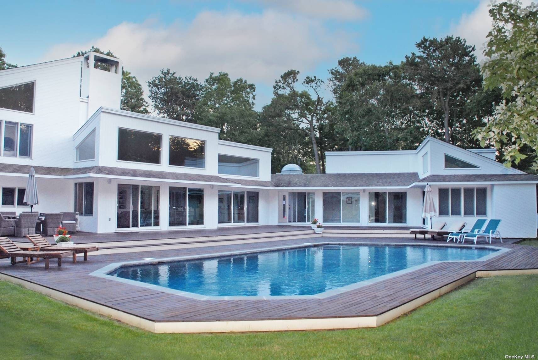 a view of a house with swimming pool and sitting area