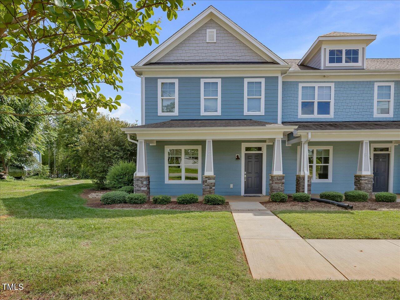 front view of a brick house with a yard