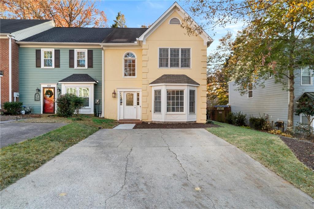 a front view of a house with yard and parking