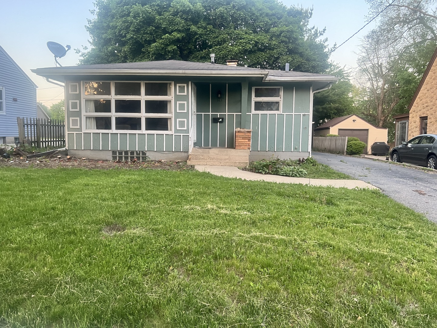 a front view of a house with a garden and yard