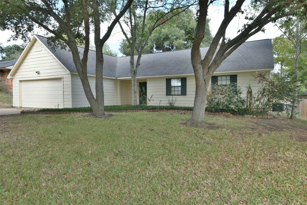 a front view of a house with a garden and tree