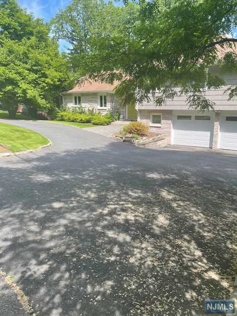 a front view of a house with a yard and lake view