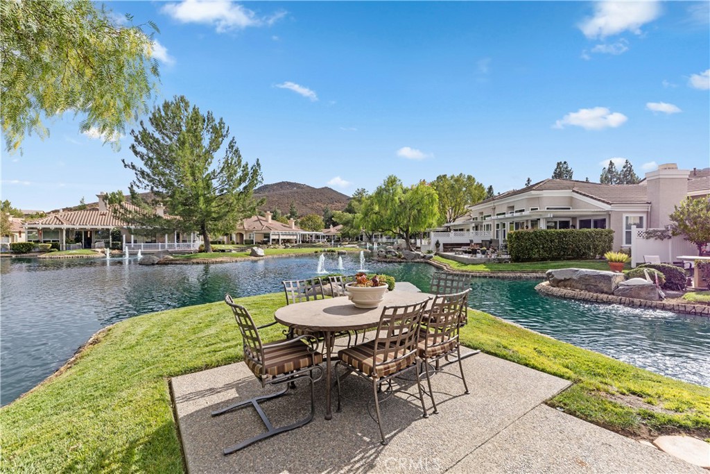 a view of a lake with couches table and chairs