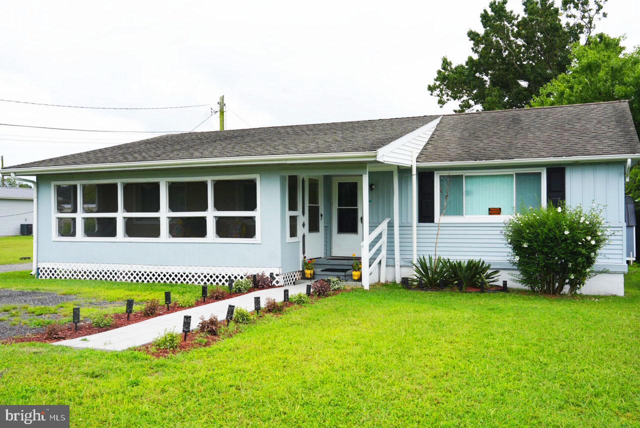 a view of a house with a yard and sitting area