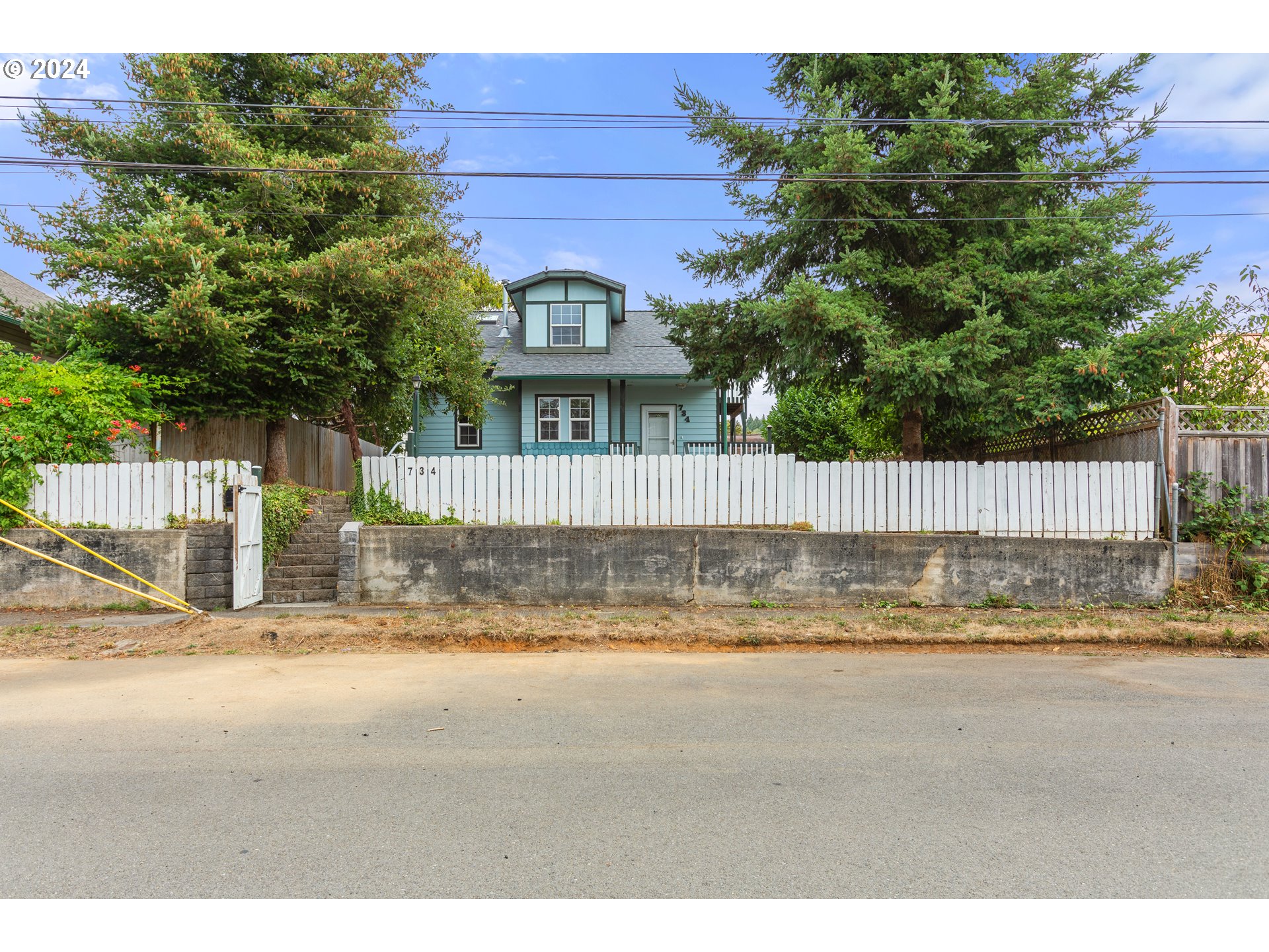 a view of a house with a yard and wooden fence