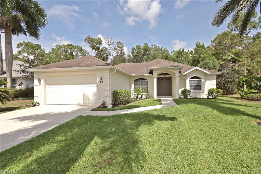 View of front of property featuring a garage and a front lawn