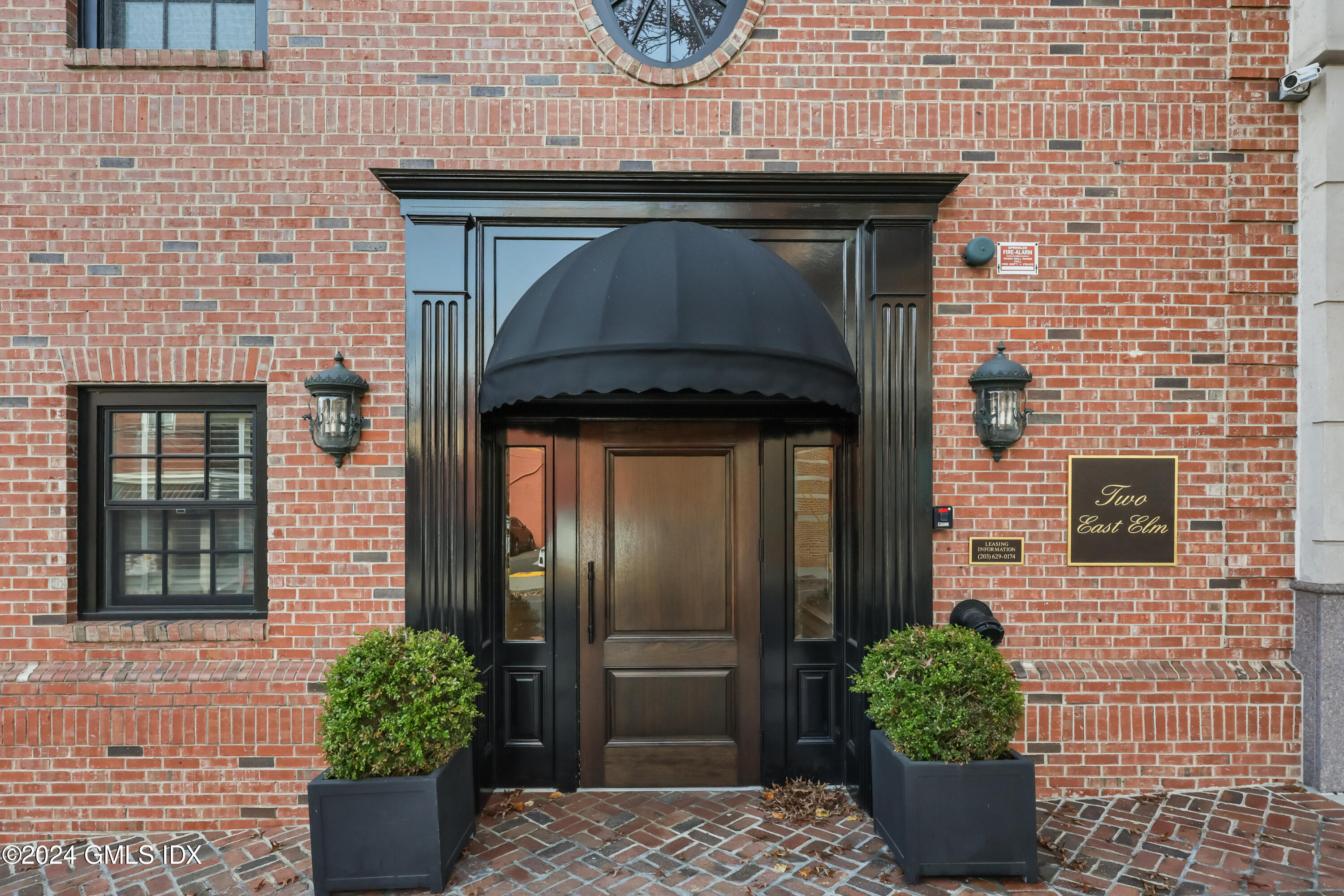 a brick house with potted plants in front of door