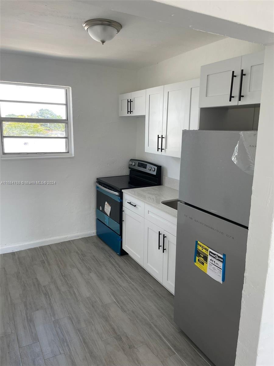 a kitchen with sink a refrigerator and a stove top oven