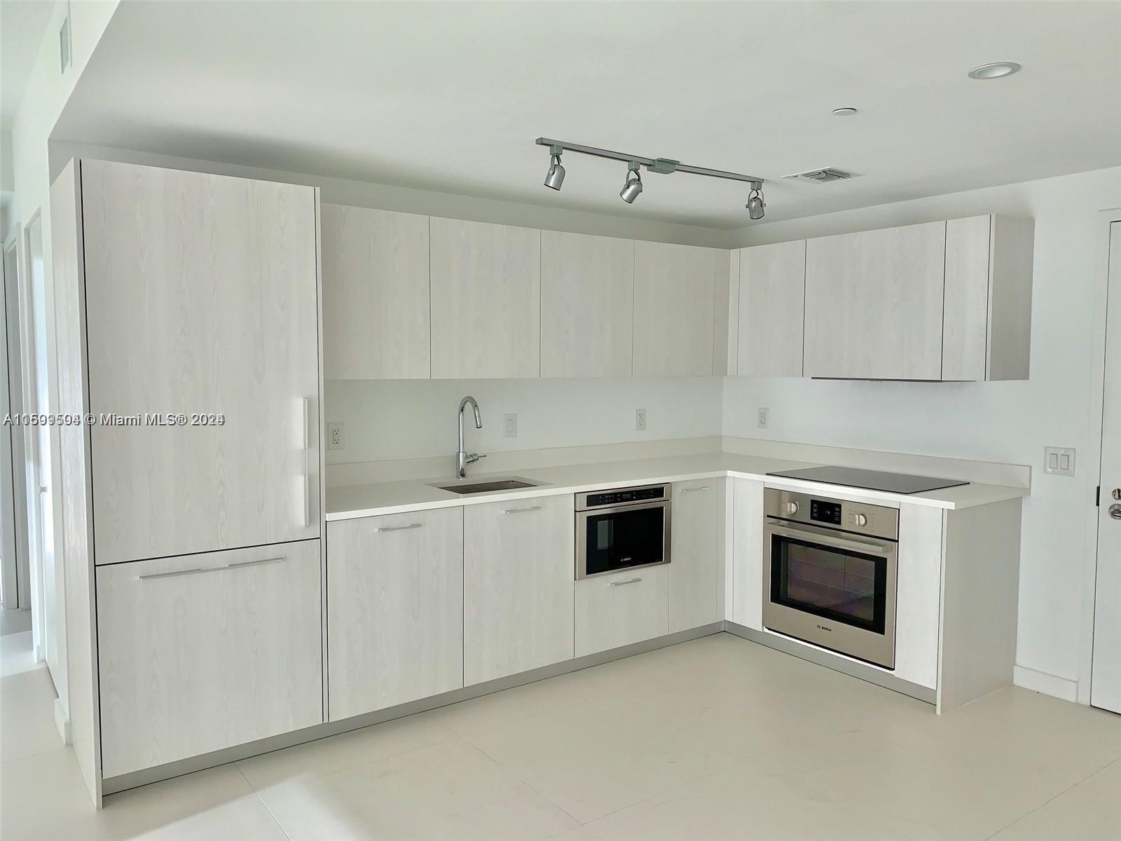 a kitchen with white cabinets and white appliances