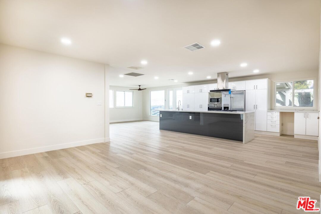 a view of kitchen with kitchen island wooden floor and center island