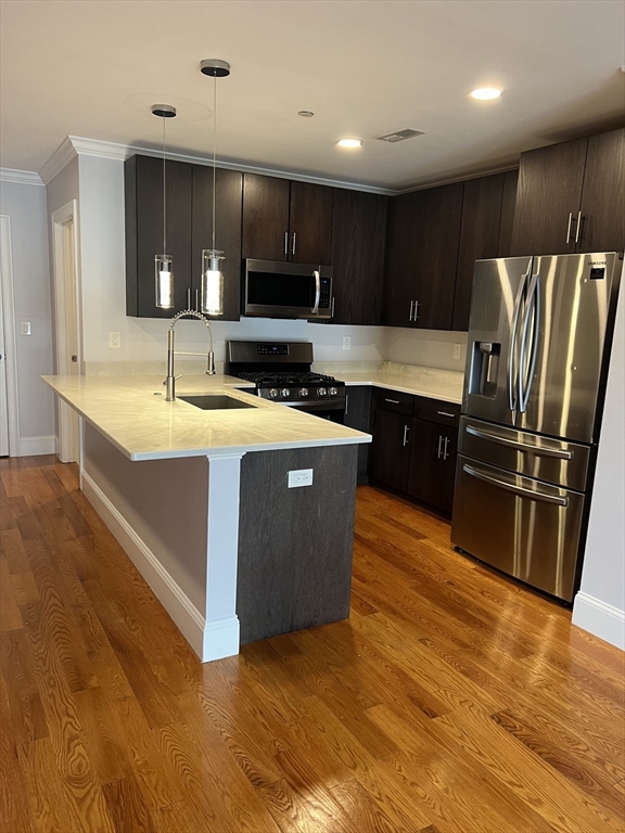 a kitchen with stainless steel appliances granite countertop a sink a stove and a refrigerator