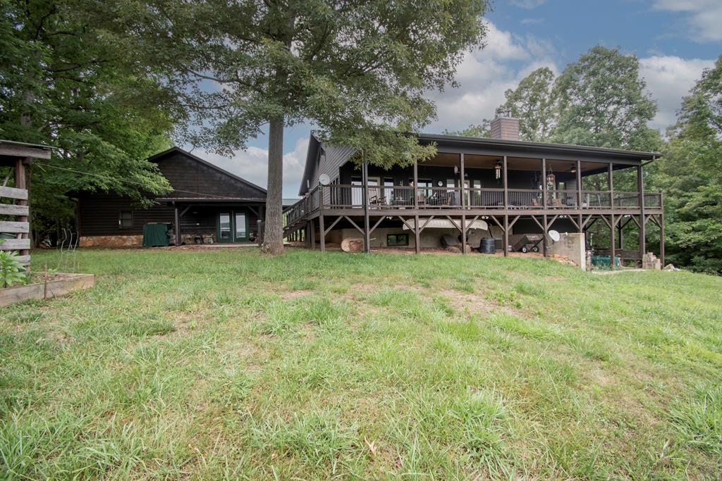 a view of a house with pool and a yard