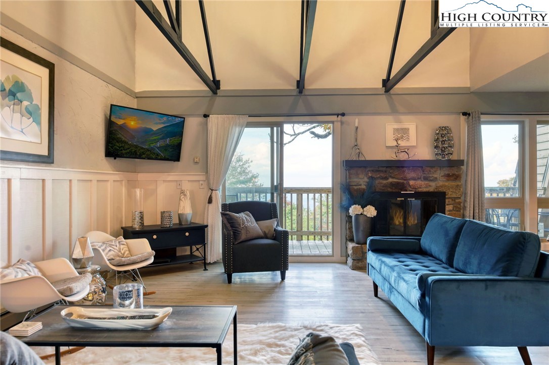 a living room with furniture a flat screen tv and a floor to ceiling window