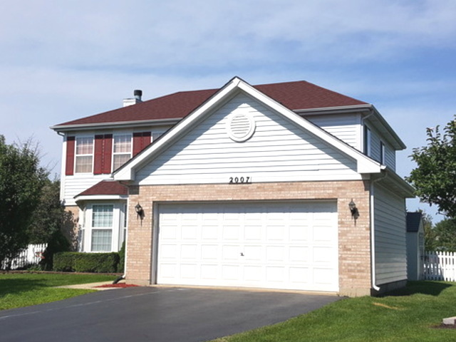 a view of house with yard and garage