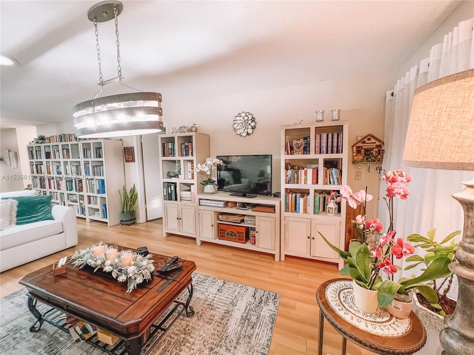 a living room with furniture flat screen tv and a table