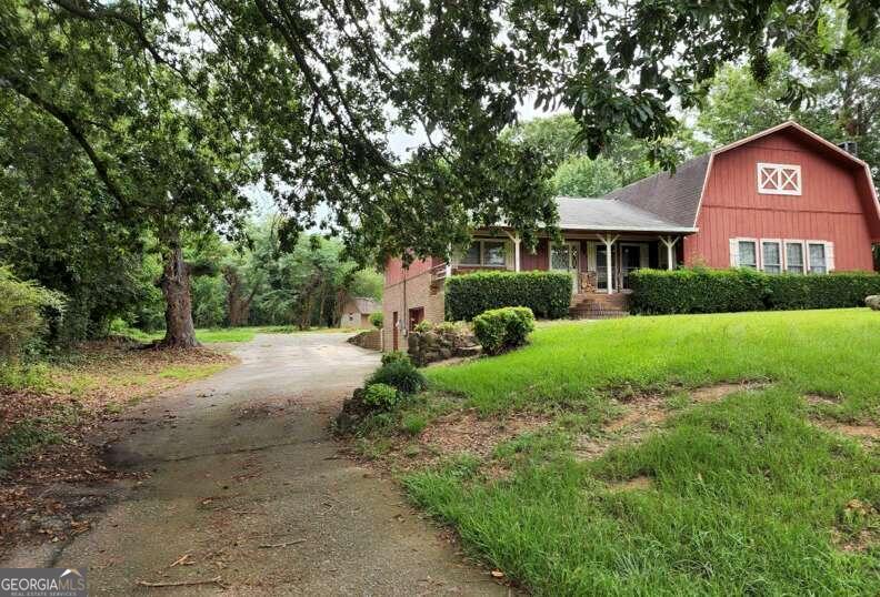 a front view of a house with yard and green space