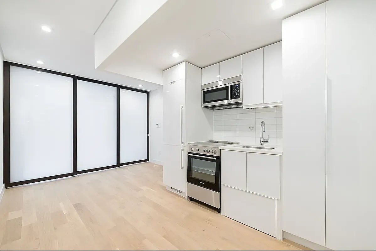 a kitchen with stainless steel appliances a refrigerator sink and microwave