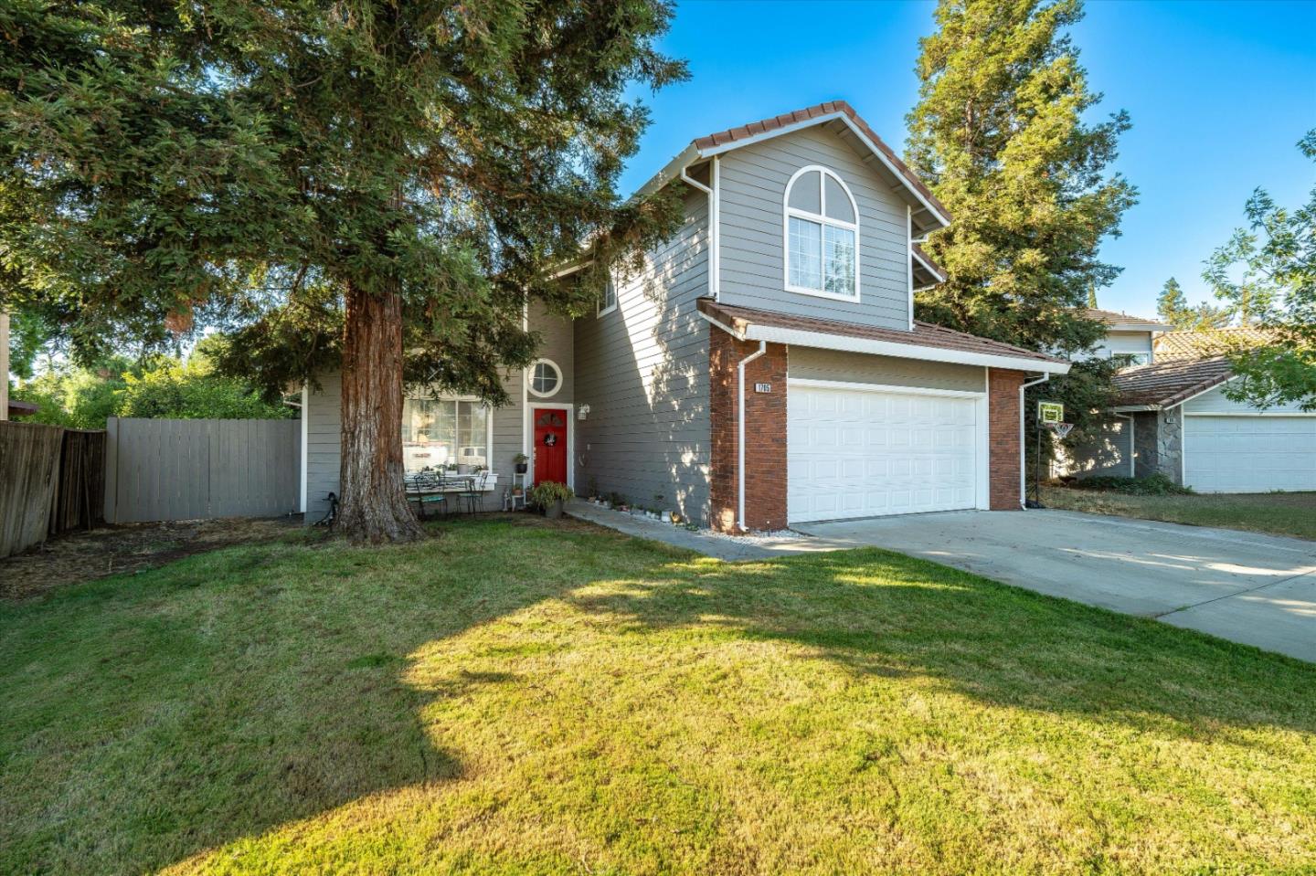 a view of an house with backyard space and a tree