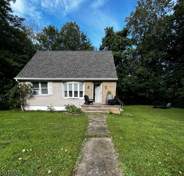 a view of a house with a yard and sitting area