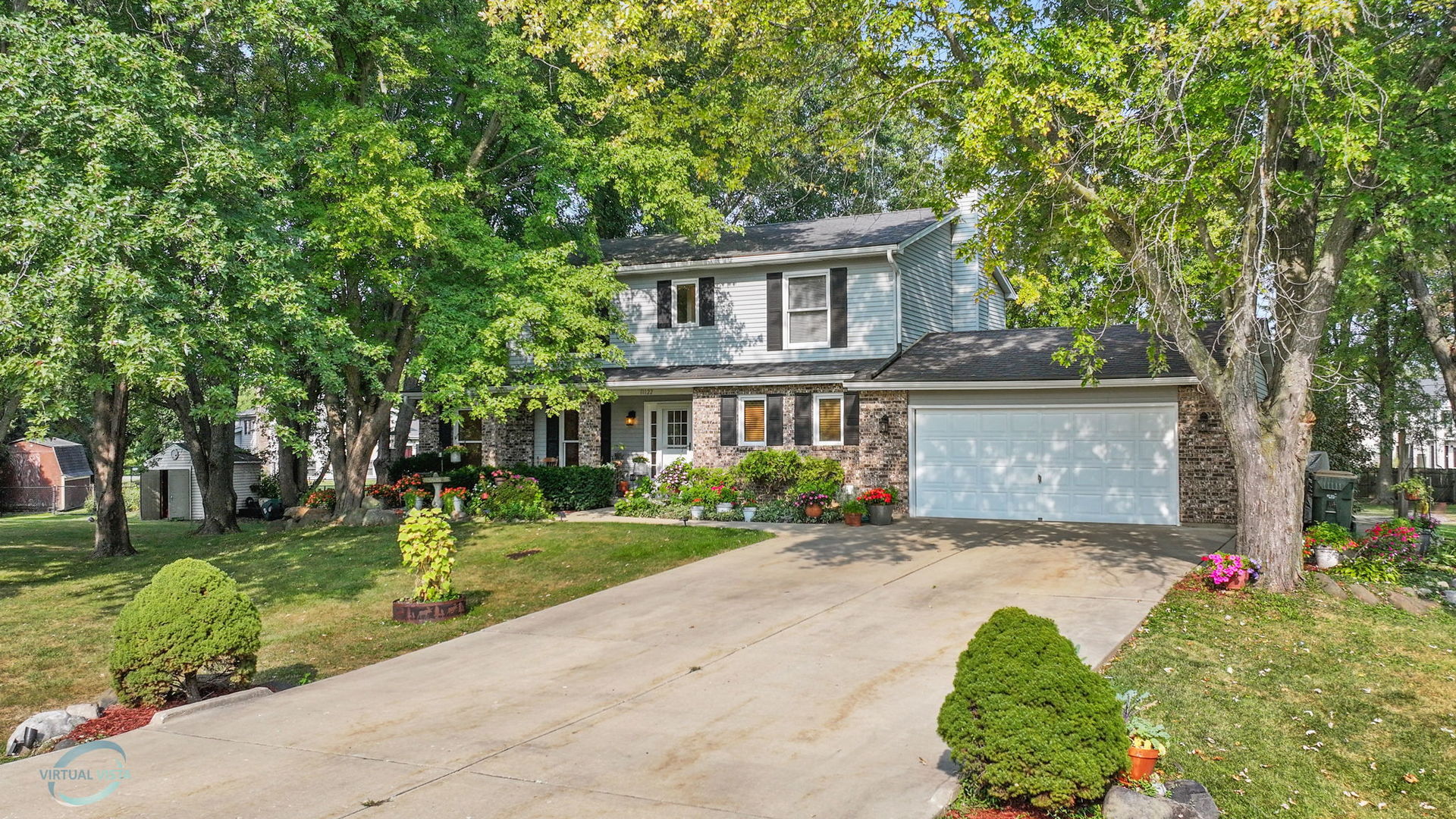 a front view of a house with a yard and trees