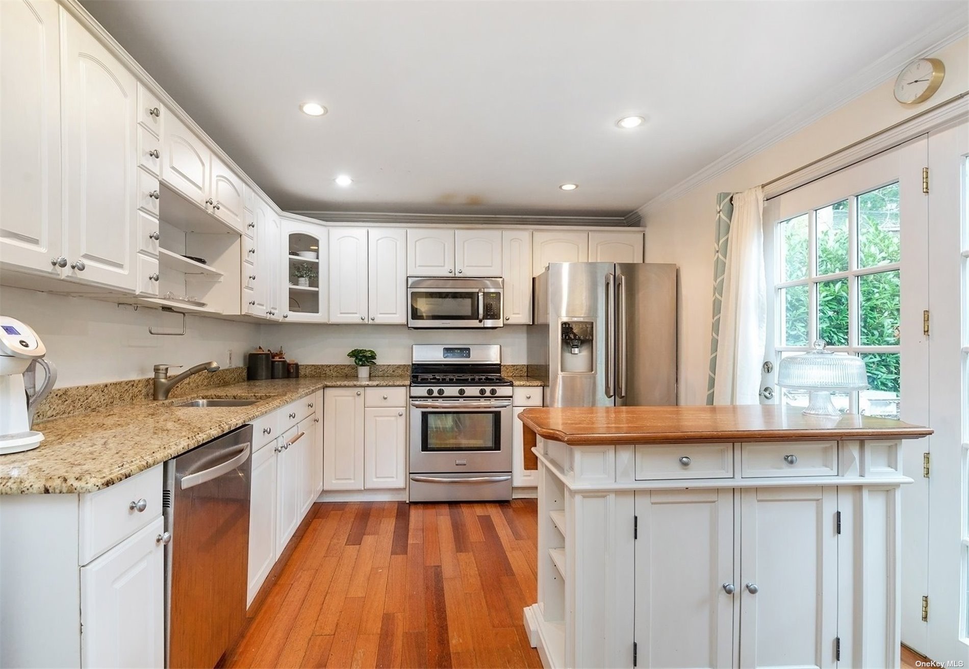 a kitchen with stainless steel appliances granite countertop a stove a sink and a refrigerator