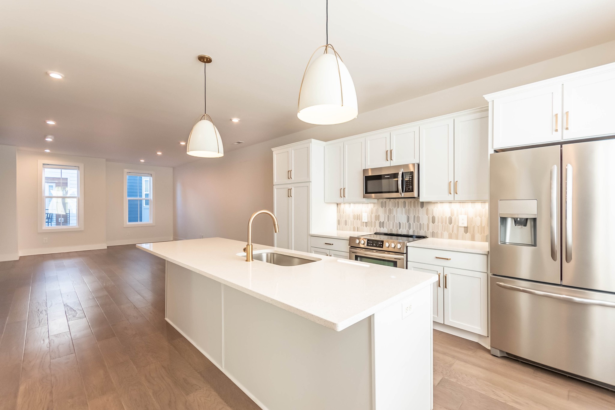 a kitchen with a sink a microwave a stove and refrigerator